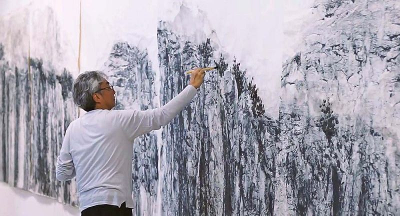 Hombre pintando un cuadro en tonos grises