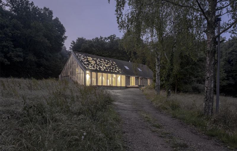 Imagen nocturna del exterior de la casa con su porche permeable