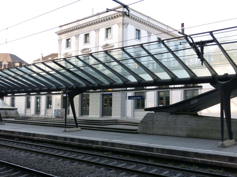 Marquesina de la vía con el edificio histórico de recepción de fondo 